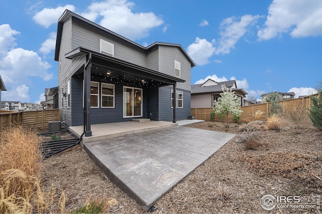 rear view of property with a fenced backyard, a patio area, and cooling unit