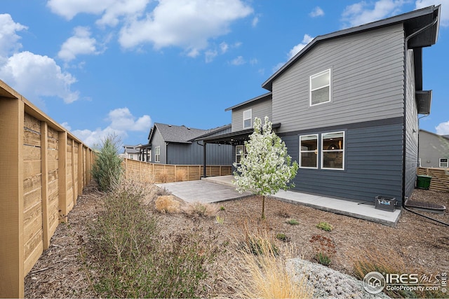 back of property with a patio area and a fenced backyard