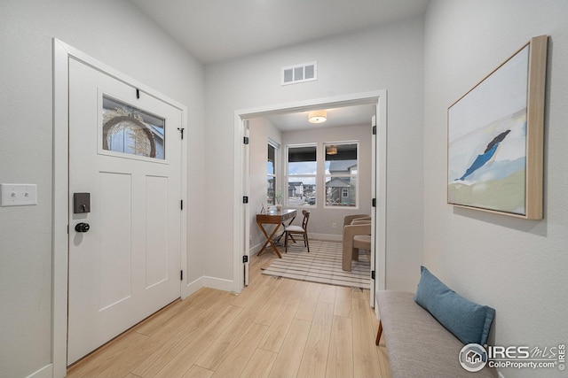 foyer entrance with light wood-type flooring, visible vents, and baseboards