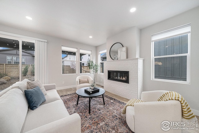 living room with recessed lighting, baseboards, wood finished floors, and a fireplace