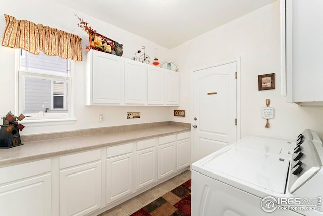 clothes washing area featuring cabinet space and washer and clothes dryer