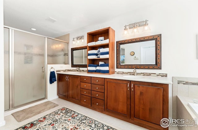 bathroom with a garden tub, a sink, double vanity, and a stall shower