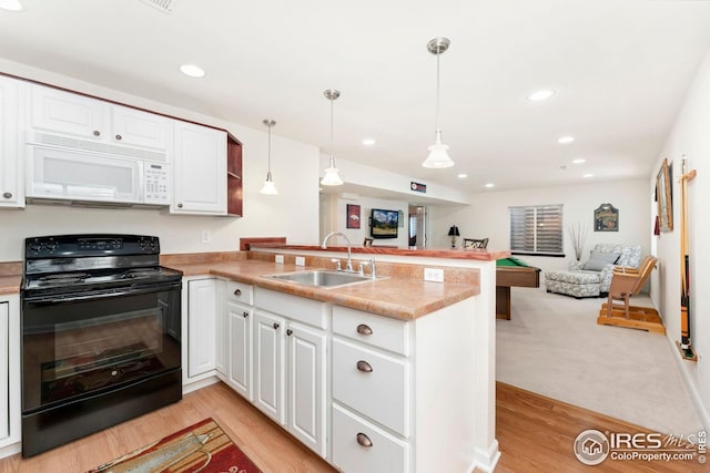 kitchen featuring a sink, open floor plan, black / electric stove, white microwave, and a peninsula