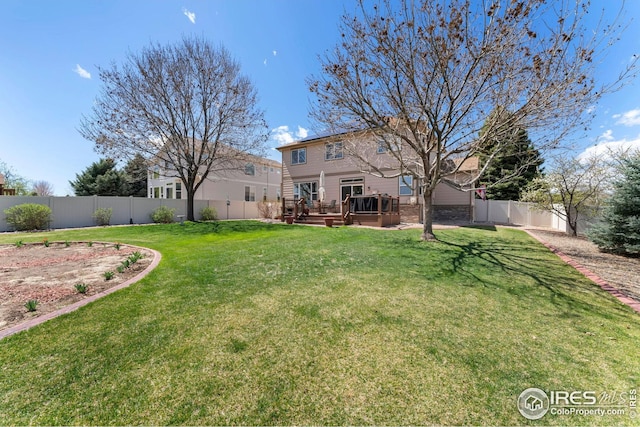 view of yard with a wooden deck and a fenced backyard