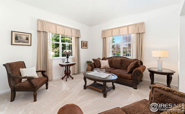 living area featuring baseboards and light colored carpet