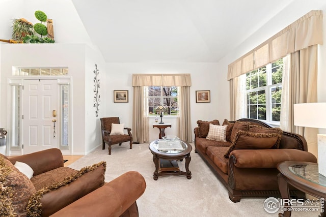 living area featuring lofted ceiling, a healthy amount of sunlight, and light carpet