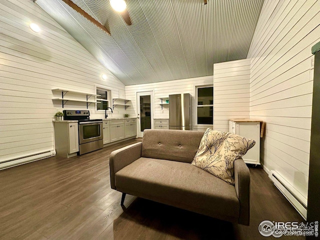 living area featuring a baseboard radiator, vaulted ceiling, a baseboard heating unit, wood walls, and dark wood-type flooring