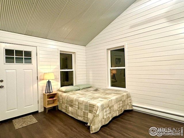 bedroom featuring baseboard heating, vaulted ceiling, dark wood-type flooring, and wooden walls