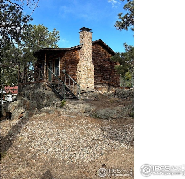 view of side of property with a chimney and stairway