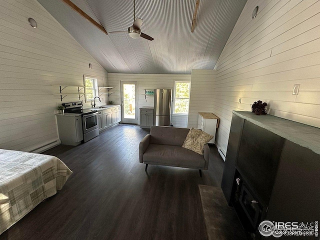 bedroom featuring dark wood-type flooring, wooden walls, freestanding refrigerator, and a sink