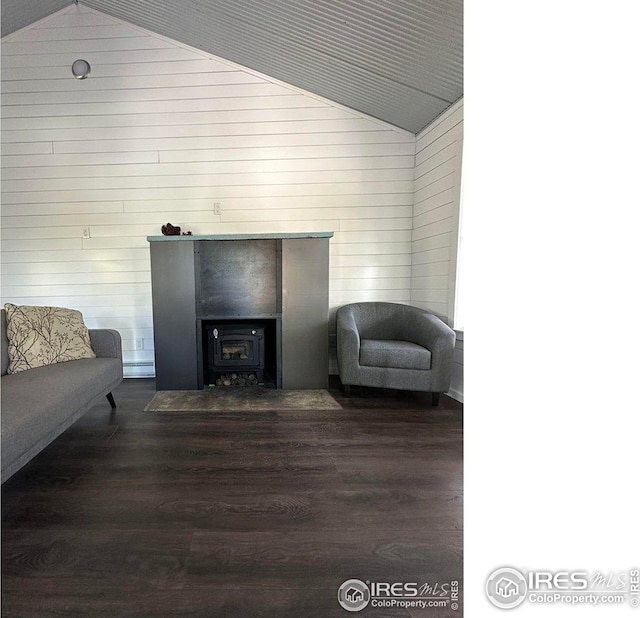 living area featuring wooden walls, lofted ceiling, and dark wood-style floors