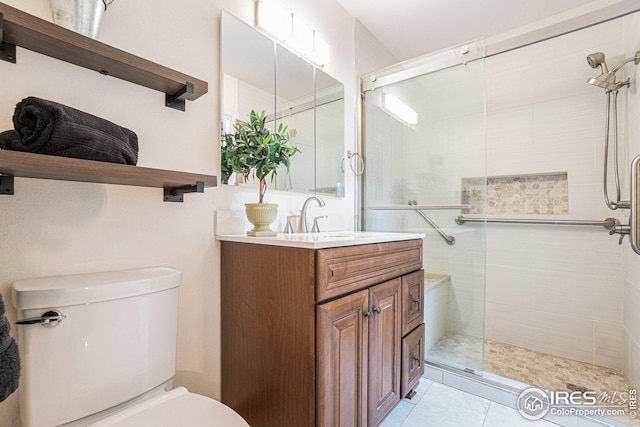 bathroom featuring toilet, vanity, and a stall shower