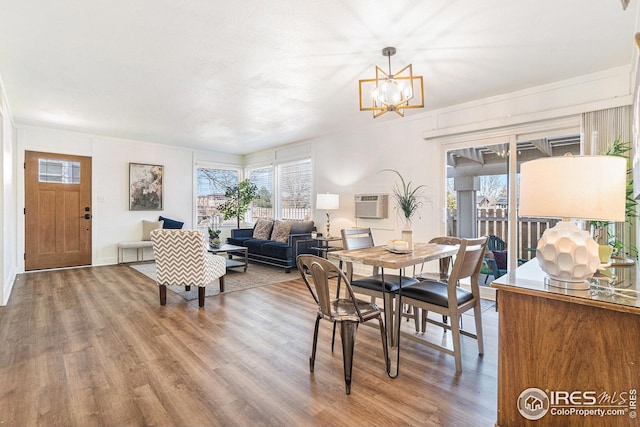 dining room with a healthy amount of sunlight, a chandelier, and wood finished floors