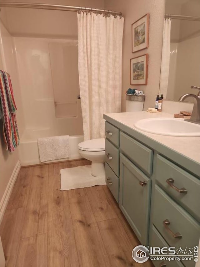 full bathroom with shower / tub combo, wood finished floors, vanity, and toilet