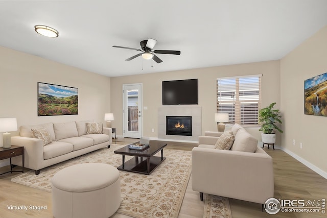 2930 W Stuart St Unit 27, Fort Collins, CO 80526 - living room with light wood-type flooring, a ceiling fan, baseboards, and a tiled fireplace