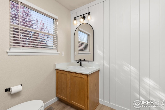 2930 W Stuart St Unit 27, Fort Collins, CO 80526 - bathroom featuring vanity, toilet, wood finished floors, and baseboards