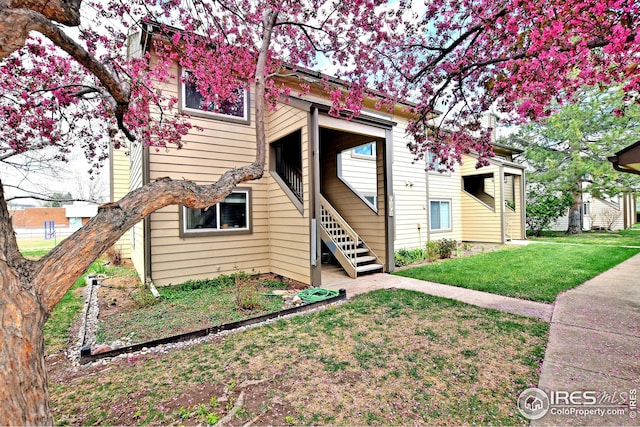 view of front of property with a front lawn and stairway