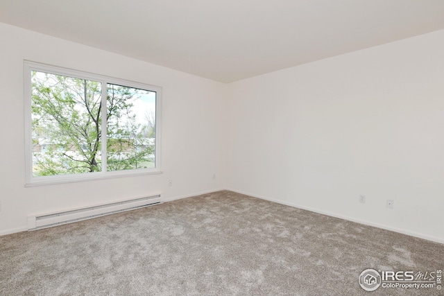 unfurnished room featuring a baseboard heating unit, carpet, and baseboards