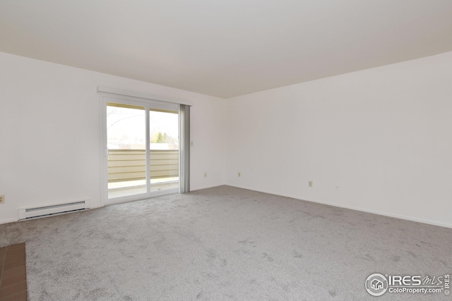 empty room featuring a baseboard heating unit, carpet floors, and baseboards