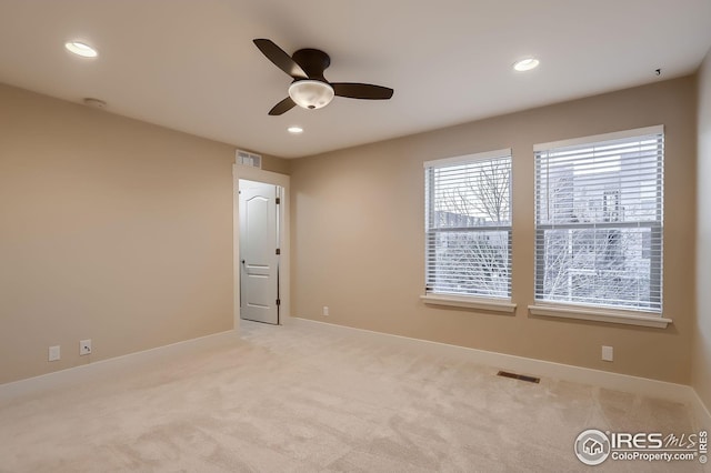 spare room with light carpet, a ceiling fan, visible vents, and recessed lighting
