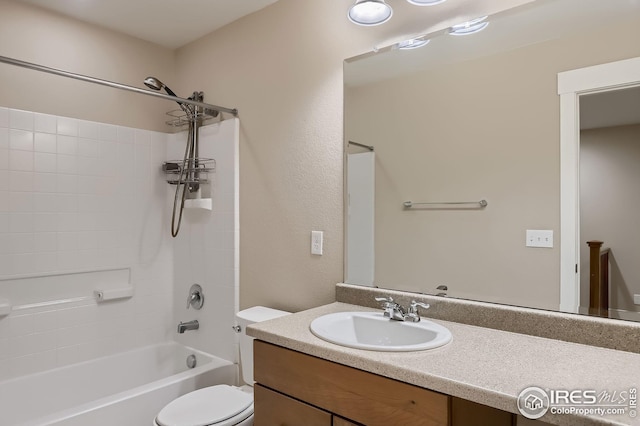 bathroom featuring toilet, vanity, and bathtub / shower combination