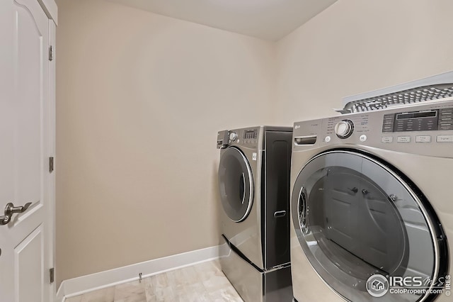 laundry room featuring washing machine and clothes dryer, baseboards, and laundry area