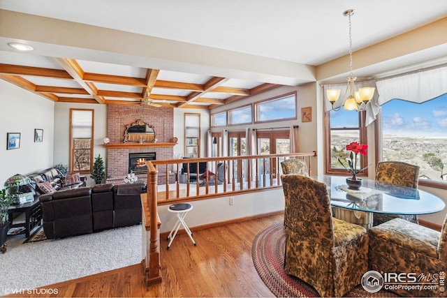 16261 W Ellsworth Ave, Golden, CO 80401 - dining space featuring wood finished floors, a chandelier, beam ceiling, a brick fireplace, and coffered ceiling