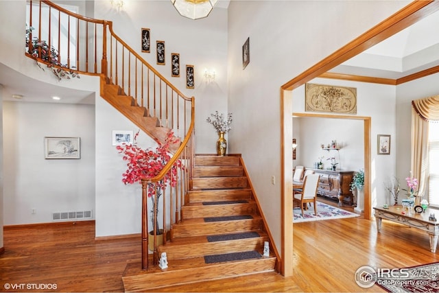 16261 W Ellsworth Ave, Golden, CO 80401 - stairway with wood finished floors, a high ceiling, baseboards, and crown molding