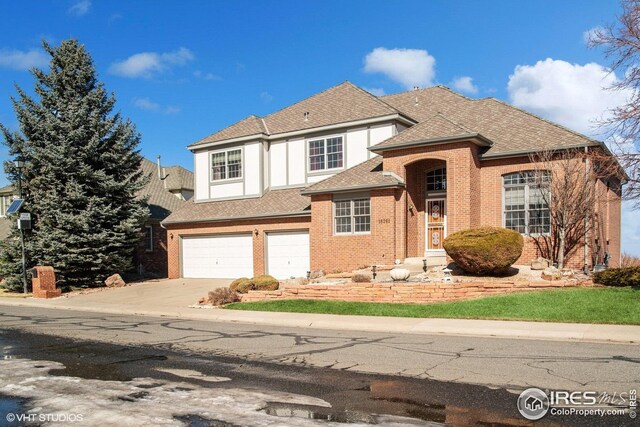 16261 W Ellsworth Ave, Golden, CO 80401 - view of front of property with a garage, concrete driveway, brick siding, and roof with shingles