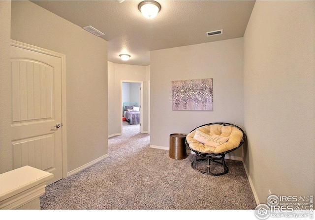 sitting room with baseboards, visible vents, and carpet flooring