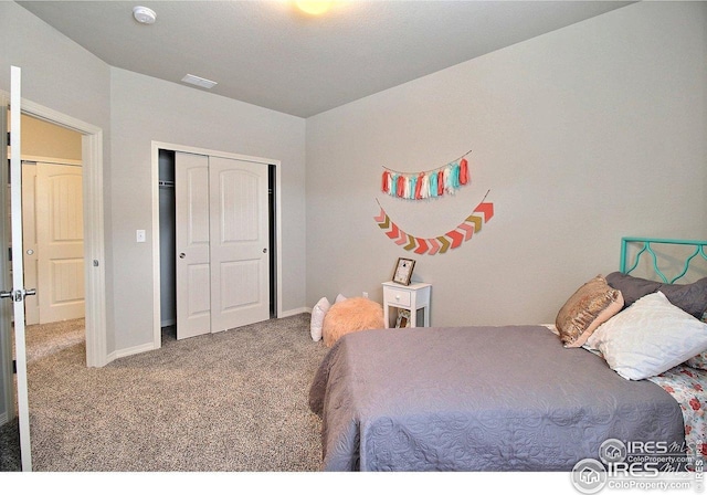 carpeted bedroom with a closet, visible vents, and baseboards