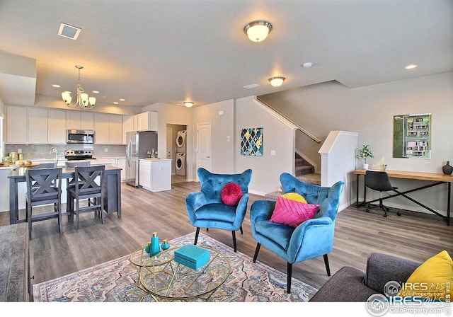 living area with recessed lighting, stairway, visible vents, light wood-type flooring, and a chandelier