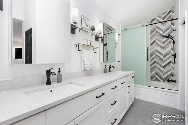 bathroom with shower / bathing tub combination, a sink, double vanity, and a decorative wall