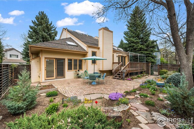 back of property with a patio area, a deck, a shingled roof, and a fenced backyard