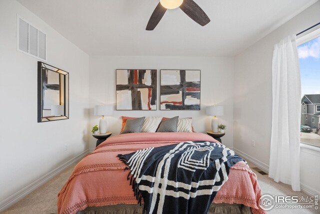 carpeted bedroom with visible vents, baseboards, and ceiling fan