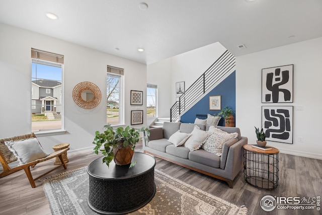 living room with baseboards, wood finished floors, recessed lighting, and stairs