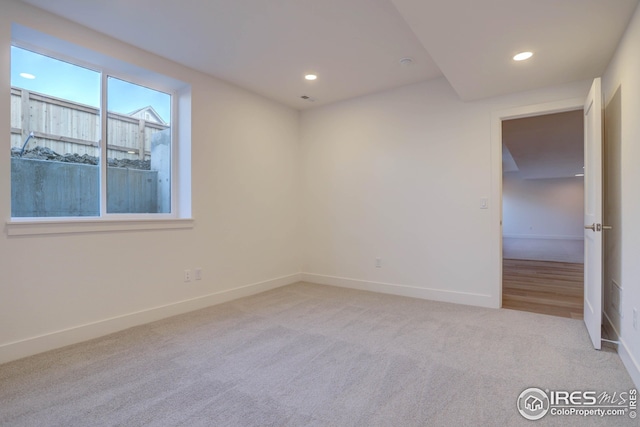 carpeted spare room featuring recessed lighting and baseboards