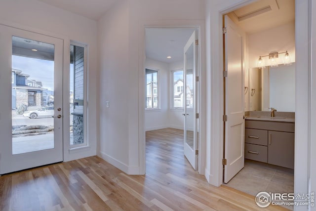 entrance foyer featuring light wood-style flooring and baseboards