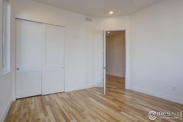 unfurnished bedroom featuring light wood finished floors, recessed lighting, a closet, visible vents, and baseboards