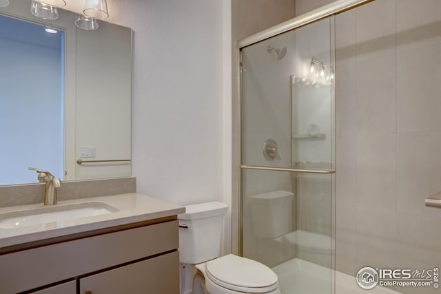 full bath featuring a shower stall, toilet, and vanity