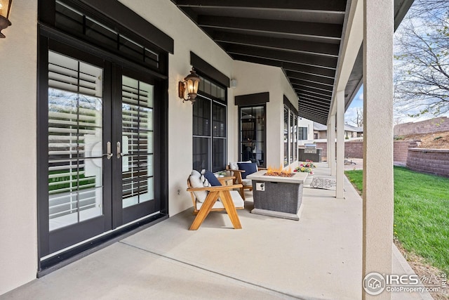 view of patio / terrace featuring fence, a fire pit, and french doors