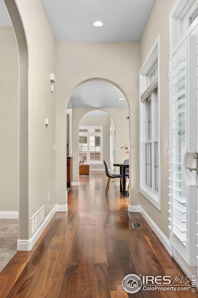 hallway featuring recessed lighting, wood finished floors, visible vents, and baseboards