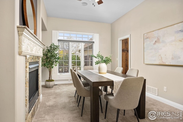 dining space featuring carpet flooring, baseboards, visible vents, ceiling fan, and a fireplace
