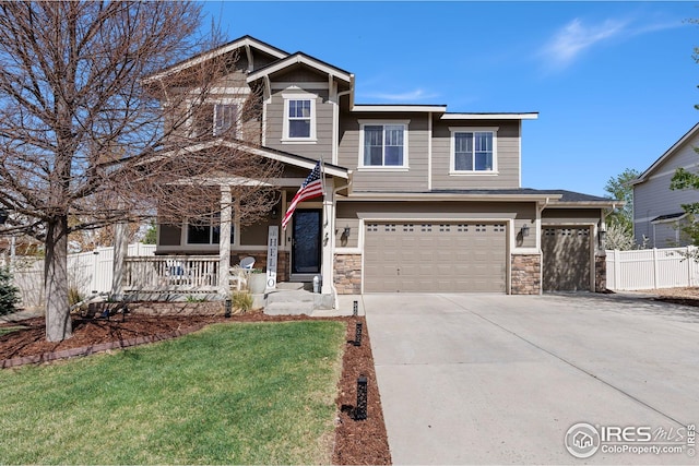 craftsman inspired home with a porch, concrete driveway, fence, a garage, and a front yard