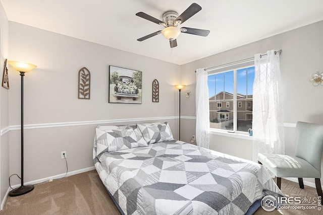 carpeted bedroom with ceiling fan and baseboards