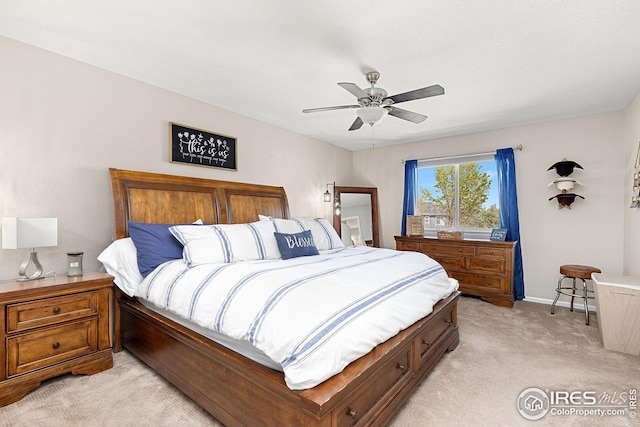 bedroom featuring light carpet, a ceiling fan, and baseboards