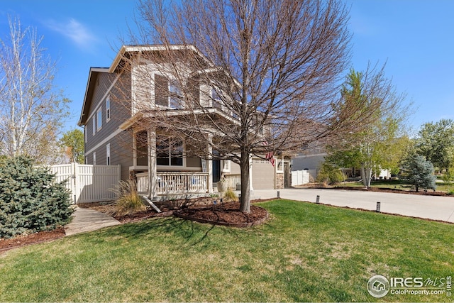 view of front of house featuring fence, driveway, covered porch, a front yard, and a garage