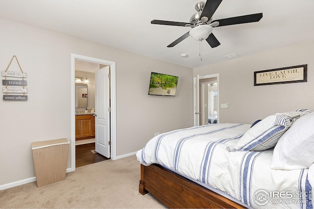 bedroom with ensuite bath, visible vents, baseboards, and light carpet