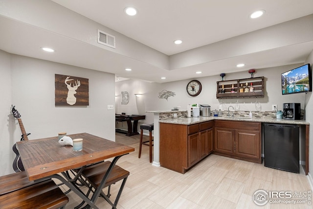 bar featuring a sink, dishwasher, wet bar, visible vents, and recessed lighting
