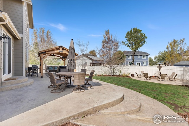 view of patio with a fenced backyard, a gazebo, an outdoor living space with a fire pit, and outdoor dining space
